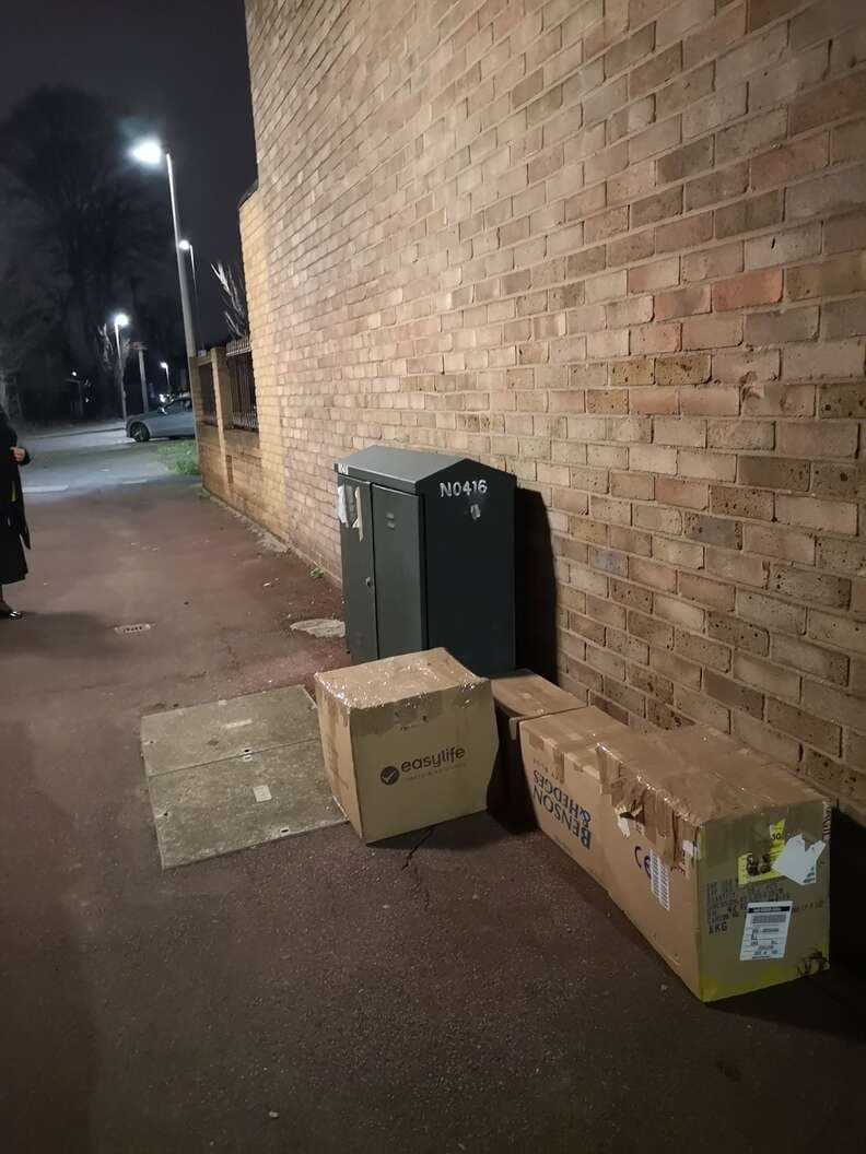 A cardboard box in a dark alleyway at night