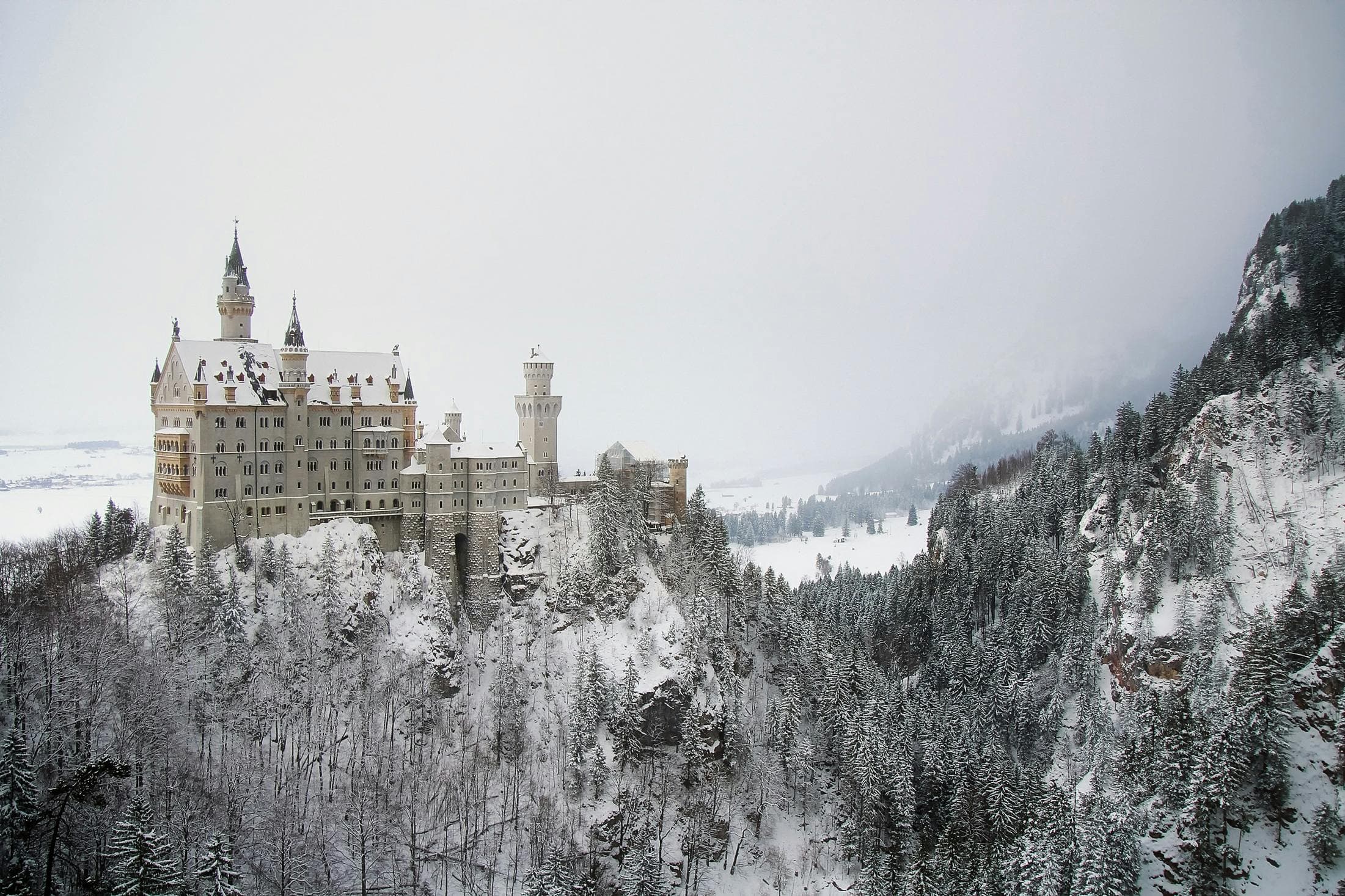 A castle on a cliffside, snowy landscape.